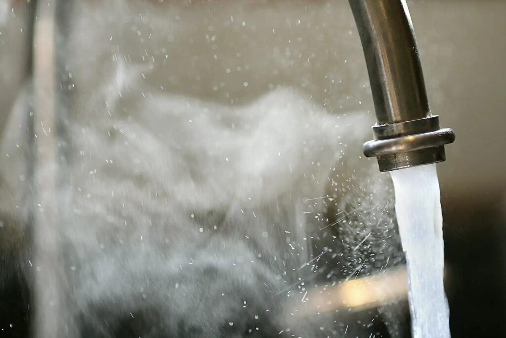 Hot water coming from kitchen faucet, with visible steam.